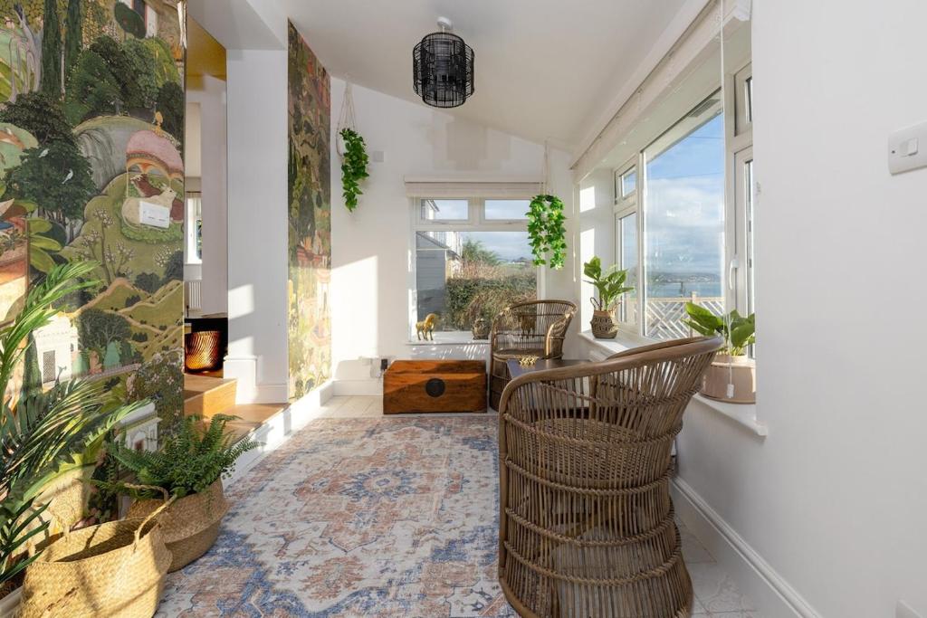a hallway with chairs and a large window at Luxury Cornish Seaview Bungalow in Looe