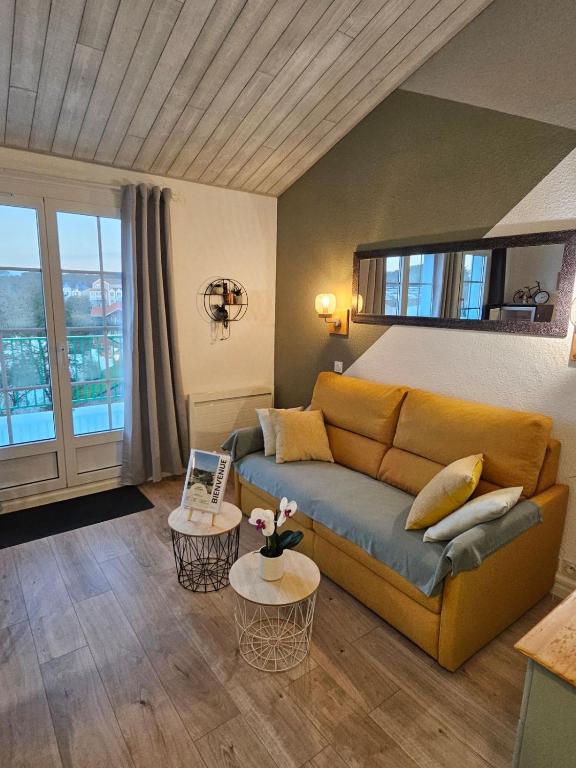 un salon avec un canapé et deux tables dans l'établissement Appt avec vue panoramique sur le lac à Port Bourgenay, à Talmont-Saint-Hilaire