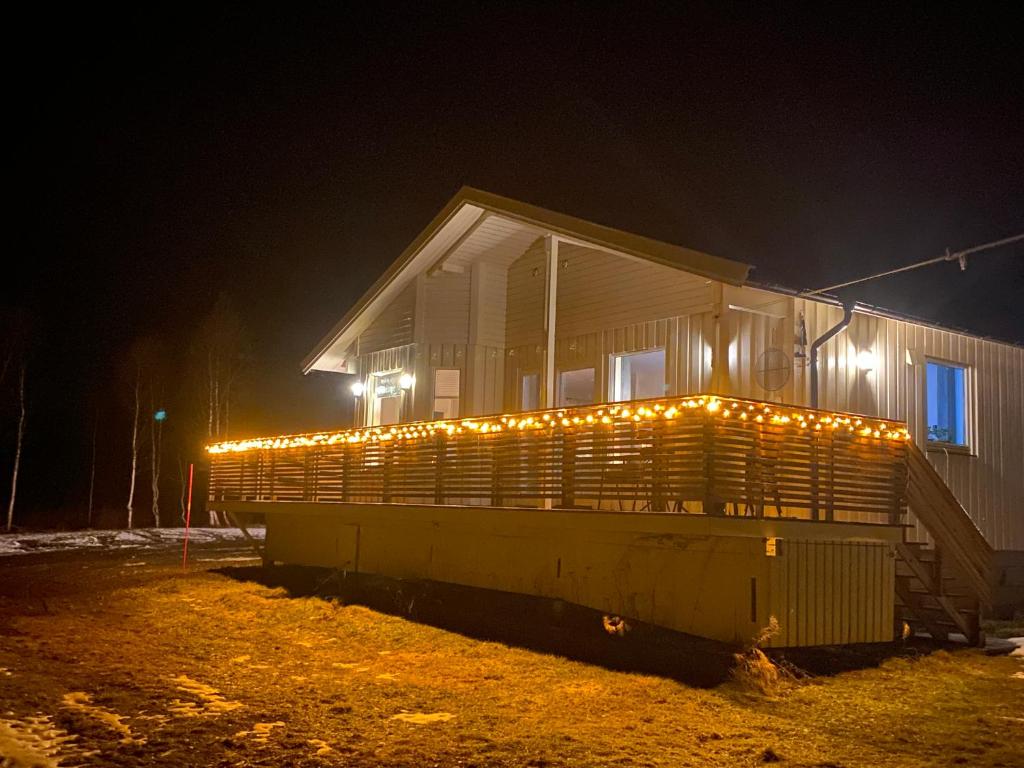 a house with lights on the side of it at night at Brygghaugen, middle of Senja in Senja