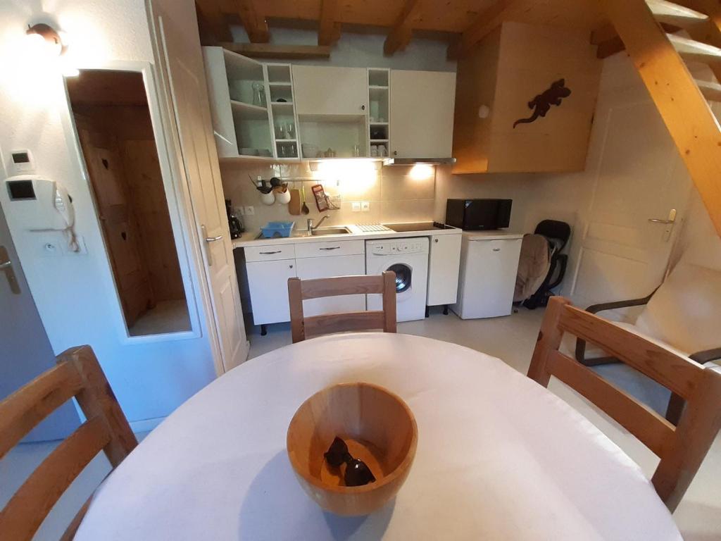 une petite cuisine avec une table et des chaises blanches dans l'établissement Studio cosy proche centre thermal avec mezzanine et wifi - FR-1-512-95, à Brides-les-Bains