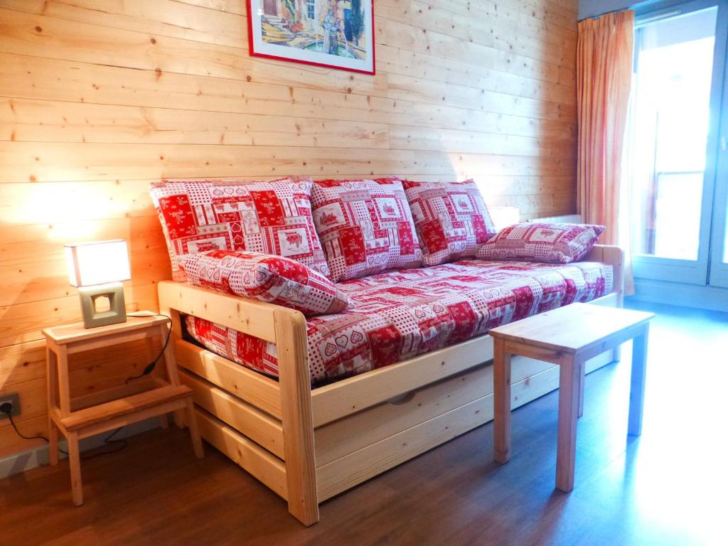 a bed in a room with a wooden wall at Studio cosy pour 4 pers, centre-ville de Brides-les-Bains, WIFI, animaux admis - FR-1-512-157 in Brides-les-Bains