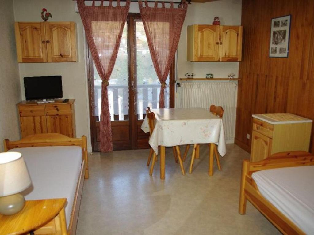 une cuisine avec une table et des chaises dans une pièce dans l'établissement Studio 2 pers avec balcon est spacieux, centre station proche thermes et télécabine, parking inclus - FR-1-512-151, à Brides-les-Bains