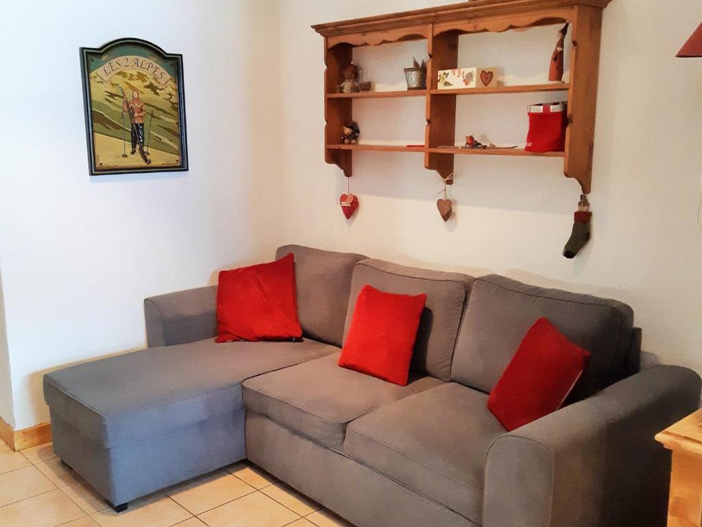 un salon avec un canapé gris avec des coussins rouges dans l'établissement Charmant 3 pièces 6 pers proche pistes avec balcon - FR-1-516-11, à Les Deux Alpes