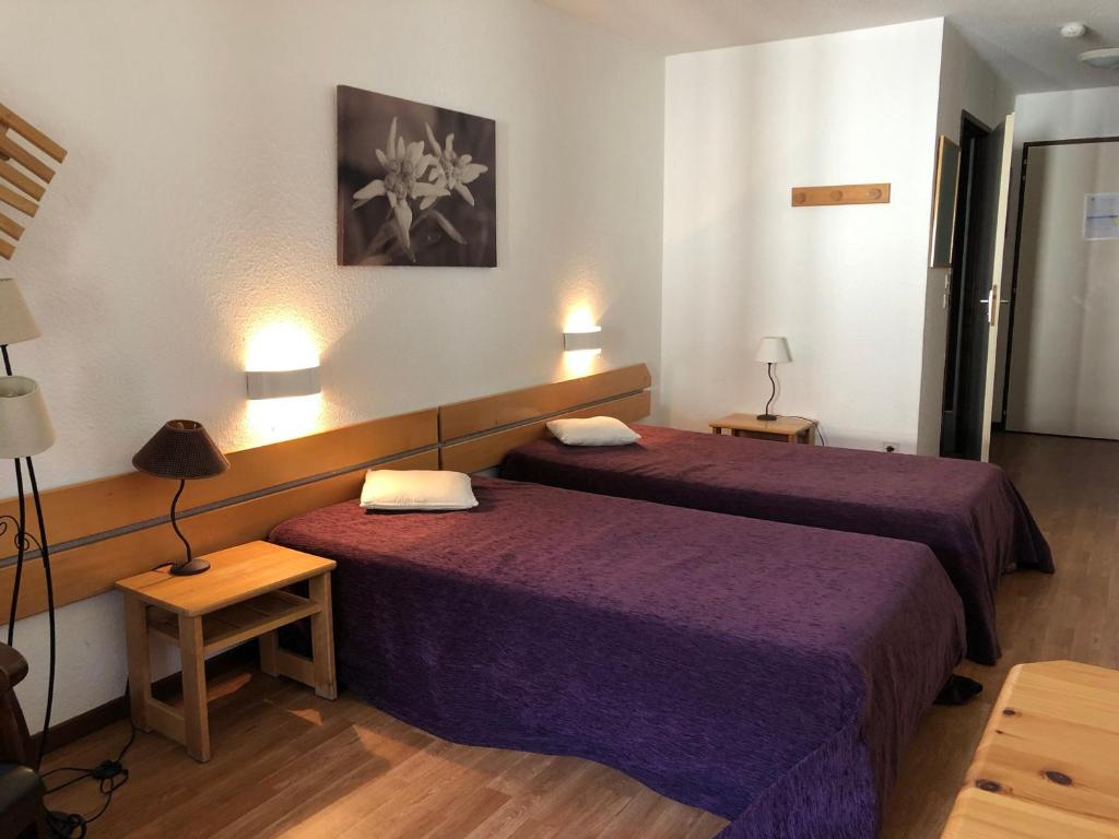 - 2 lits dans une chambre d'hôtel avec des draps violets dans l'établissement Studio avec Balcon, WIFI et Parking - 4 pers, Proche Thermes, Brides-les-Bains - FR-1-512-164, à Brides-les-Bains