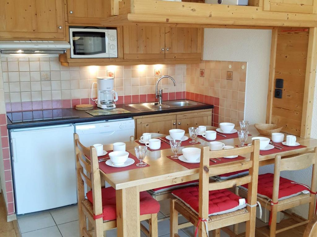 - une cuisine avec une table, des chaises et un évier dans l'établissement Appartement rénové aux Deux Alpes, pied des pistes, balcon, parking - FR-1-516-28, à Les Deux Alpes