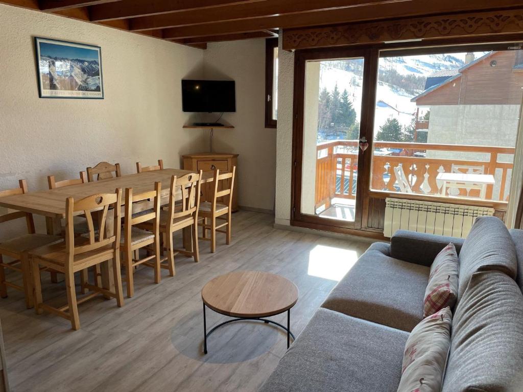 un salon avec un canapé, une table et des chaises dans l'établissement Duplex Montagne avec Balcon au Pied des Pistes, 8 Pers., Parking Privé - FR-1-516-102, à Les Deux Alpes