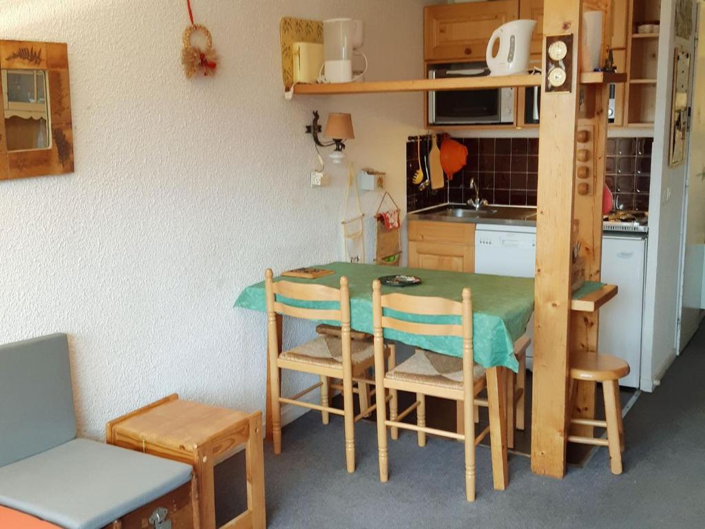 une cuisine avec une table et des chaises dans une pièce dans l'établissement Studio cosy au pied des pistes avec balcon et parking - FR-1-516-103, à Les Deux Alpes