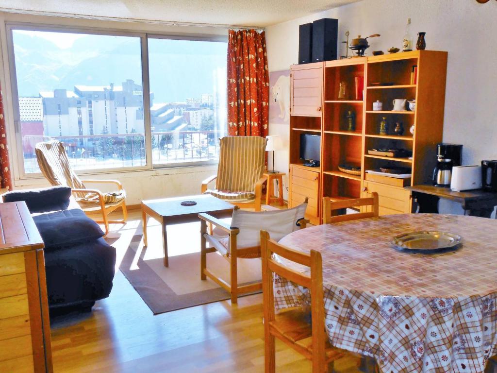 a living room with a table and chairs and a large window at Appartement cosy centre station, au pied des pistes, 2 pièces, parking, 6 pers - FR-1-516-99 in Les Deux Alpes