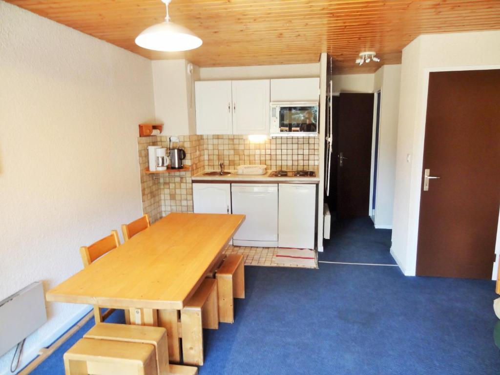- une cuisine avec une table en bois dans une chambre dans l'établissement À deux pas des pistes et de la crèche, appartement cosy avec terrasse, parking et casier à ski. - FR-1-516-66, à Les Deux Alpes