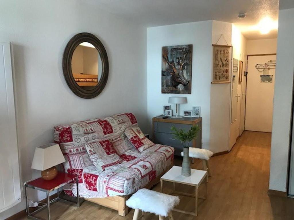 a living room with a couch and a mirror at Studio 4 Pers avec Balcon, Wi-Fi, Parking - Centre-ville Brides-les-Bains - FR-1-512-231 in Brides-les-Bains