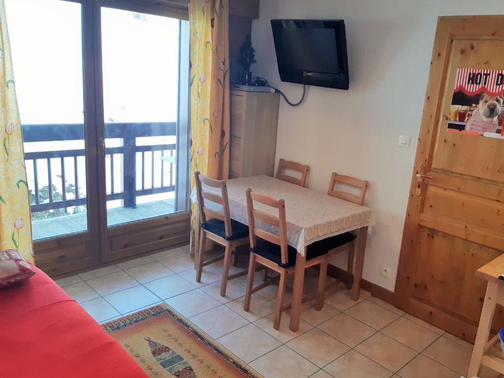 une salle à manger avec une table, des chaises et une télévision dans l'établissement Appartement 2 pièces avec balcon - Pied des pistes, secteur calme - FR-1-516-145, à Mont-de-Lans