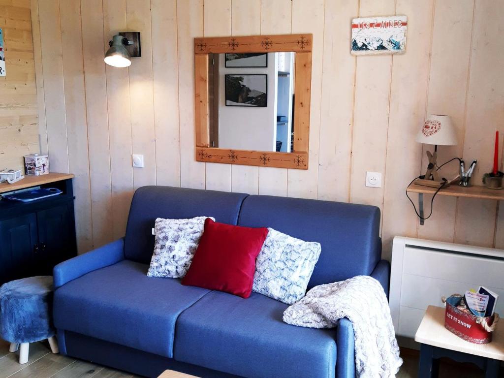 - un canapé bleu avec des oreillers dans l'établissement Charmant appartement rénové 4 pers, balcon, pied des pistes, animaux admis - FR-1-516-154, à Les Deux Alpes