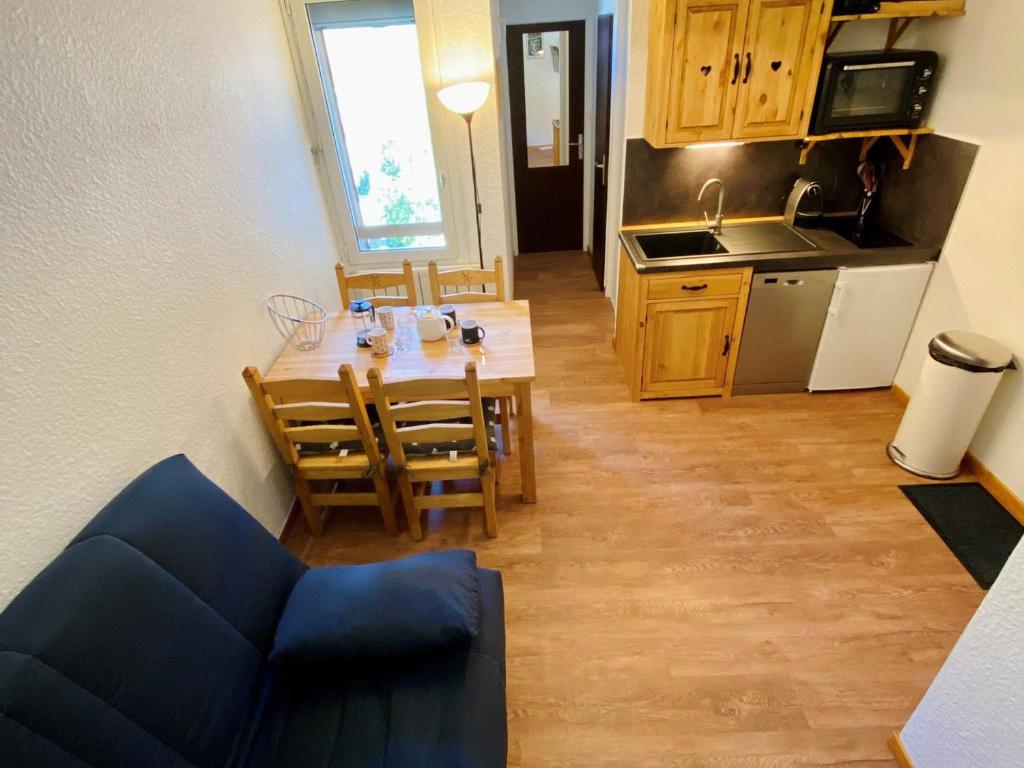 une cuisine et une salle à manger avec une table et des chaises dans l'établissement Charmant T2 au pied des pistes, 4 pers., équipement moderne, centre station, près des commerces - FR-1-516-169, à Les Deux Alpes