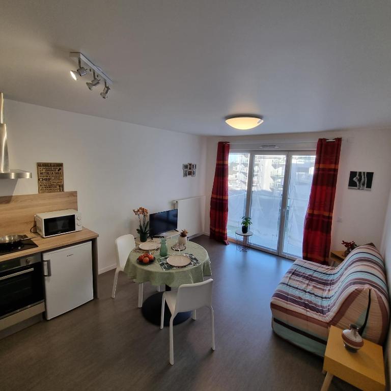 une cuisine et un salon avec une table et un canapé dans l'établissement Résidence NOVAGE - Amiens, à Amiens