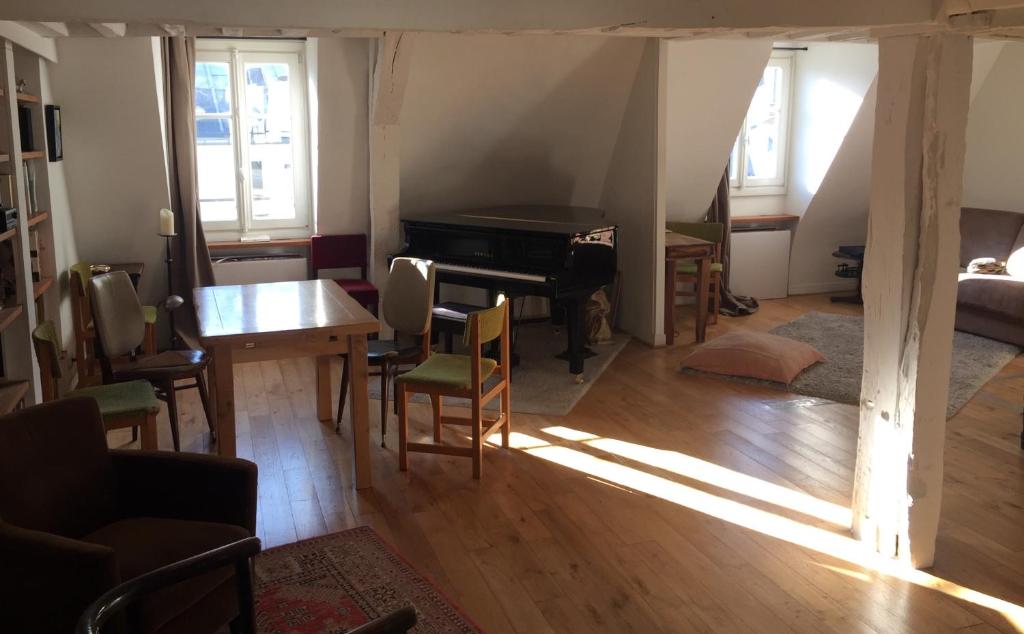 - un salon avec un piano, une table et des chaises dans l'établissement Loft Duplex Centre Paris, à Paris