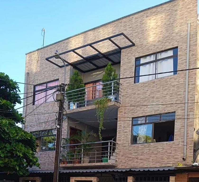 un edificio de ladrillo con un balcón en el lateral. en CASA VACANZA Cenaida Mono Titi, en Leticia