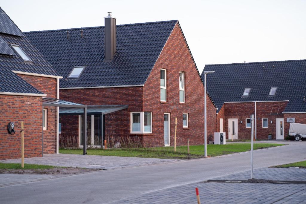 a row of brick houses with black roofs at Ferienhaus Deichliebe in Fedderwarderdeich