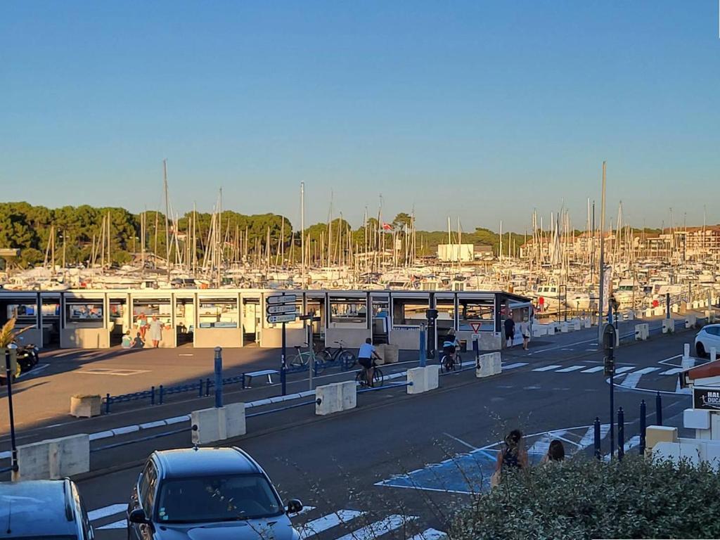 un parking avec des voitures et un port de plaisance avec des bateaux dans l'établissement Résidence l'ACCALMIE- Appartement pour 4 personnes proche du port de pêche, à Capbreton