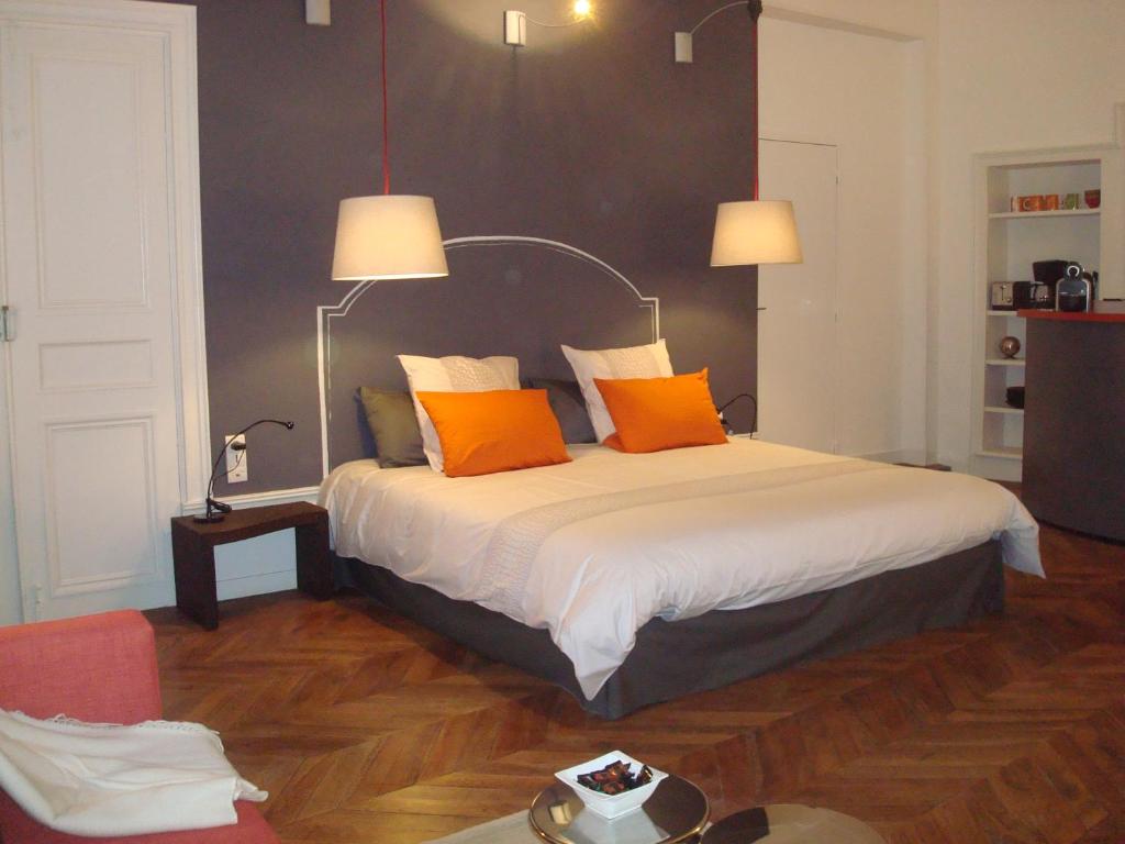 a bedroom with a bed with orange pillows on it at Appartements Caractere Clos St Jean in Mâcon
