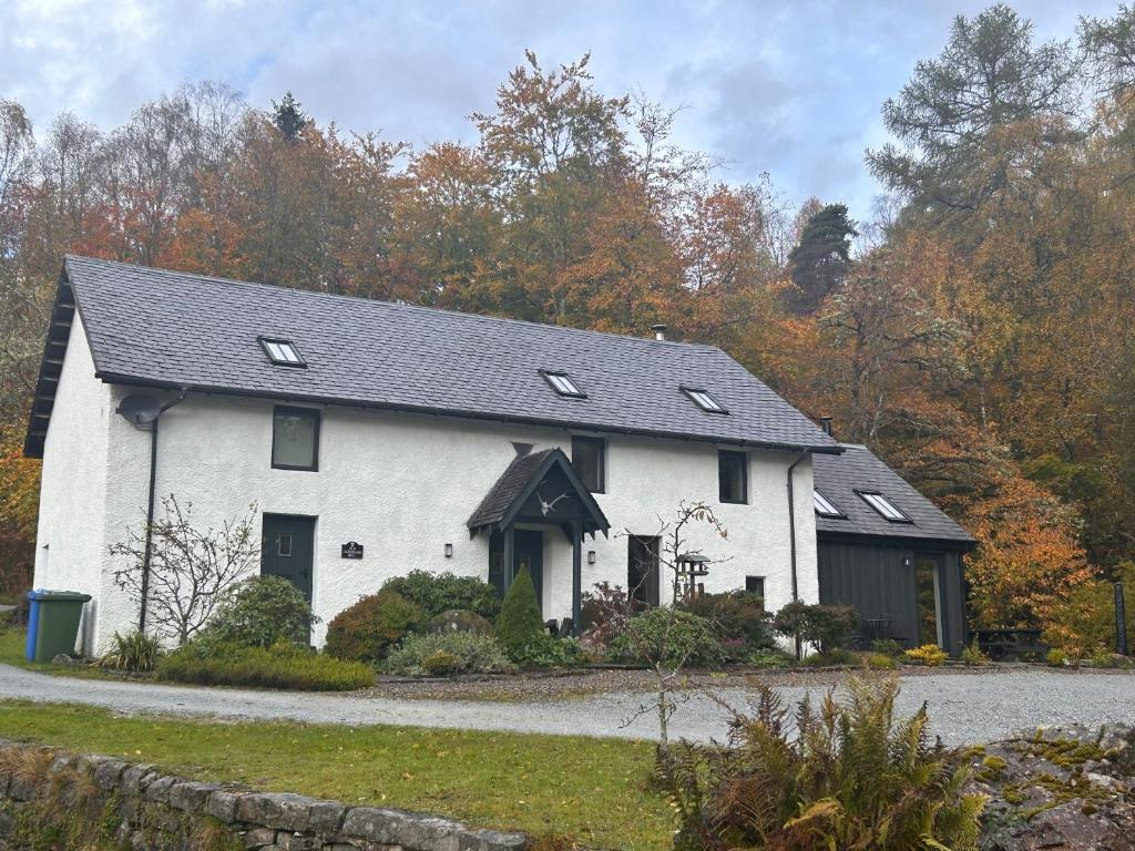 a white house with a black roof at Aldernaig Mill in Invergarry