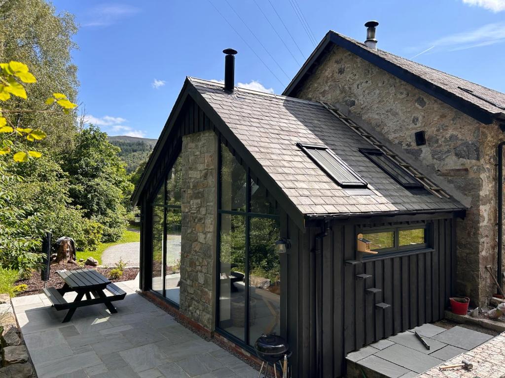 a large glass extension to a stone house at Aldernaig Mill in Invergarry