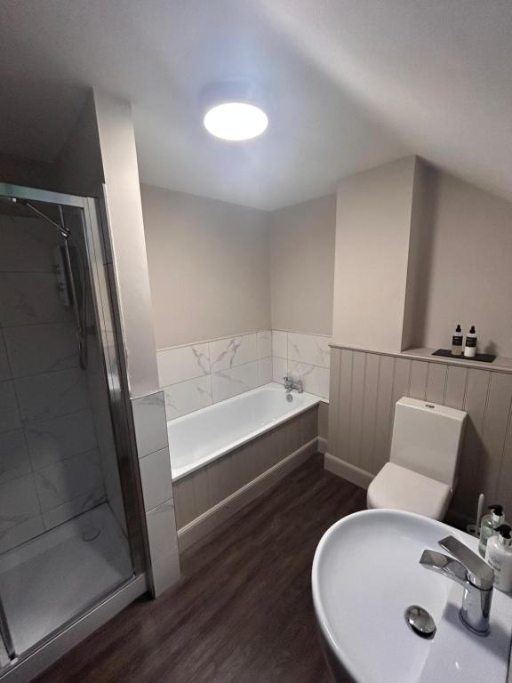 a bathroom with a sink and a tub and a toilet at Aldernaig Mill in Invergarry