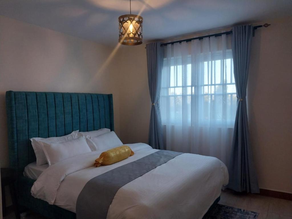 a bedroom with a large bed with a large window at Alorabnb in Ongata Rongai 