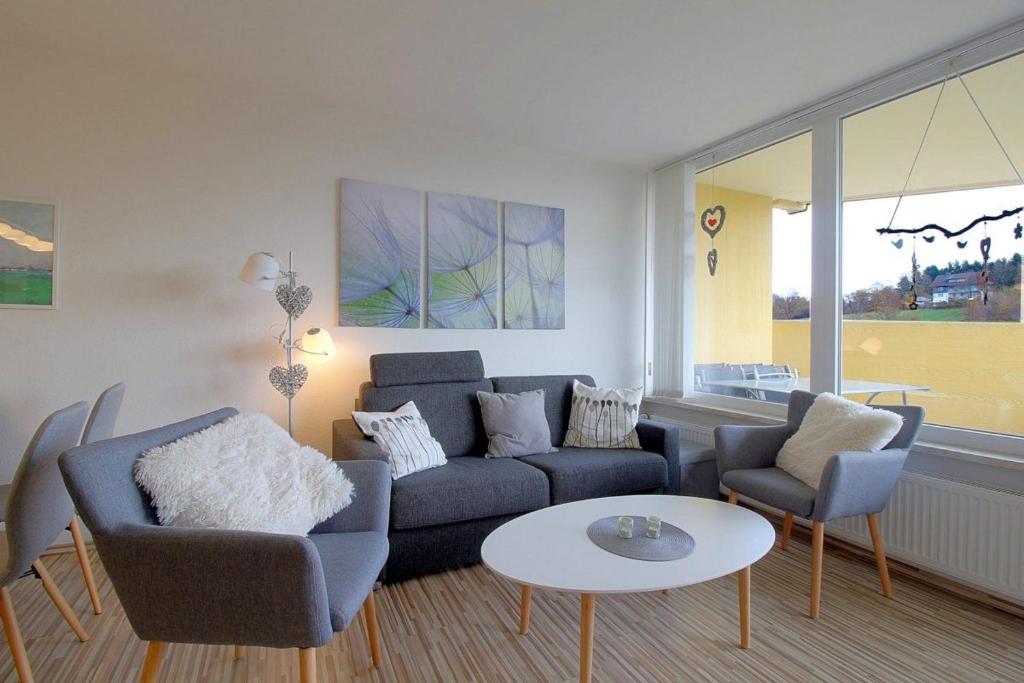een woonkamer met een bank, stoelen en een tafel bij Apartment 238 in Hohegeiß