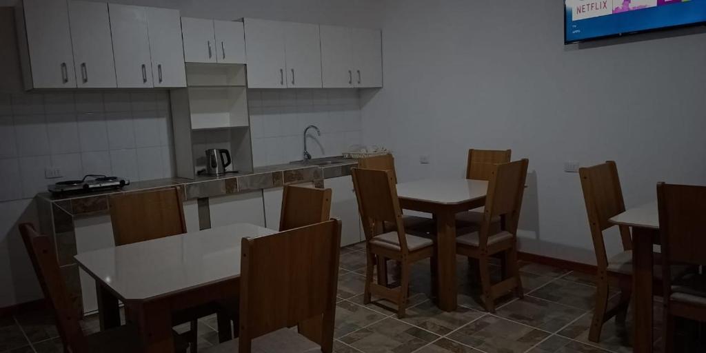 a kitchen with two tables and chairs and a counter at Hostal Panul in Panulcillo