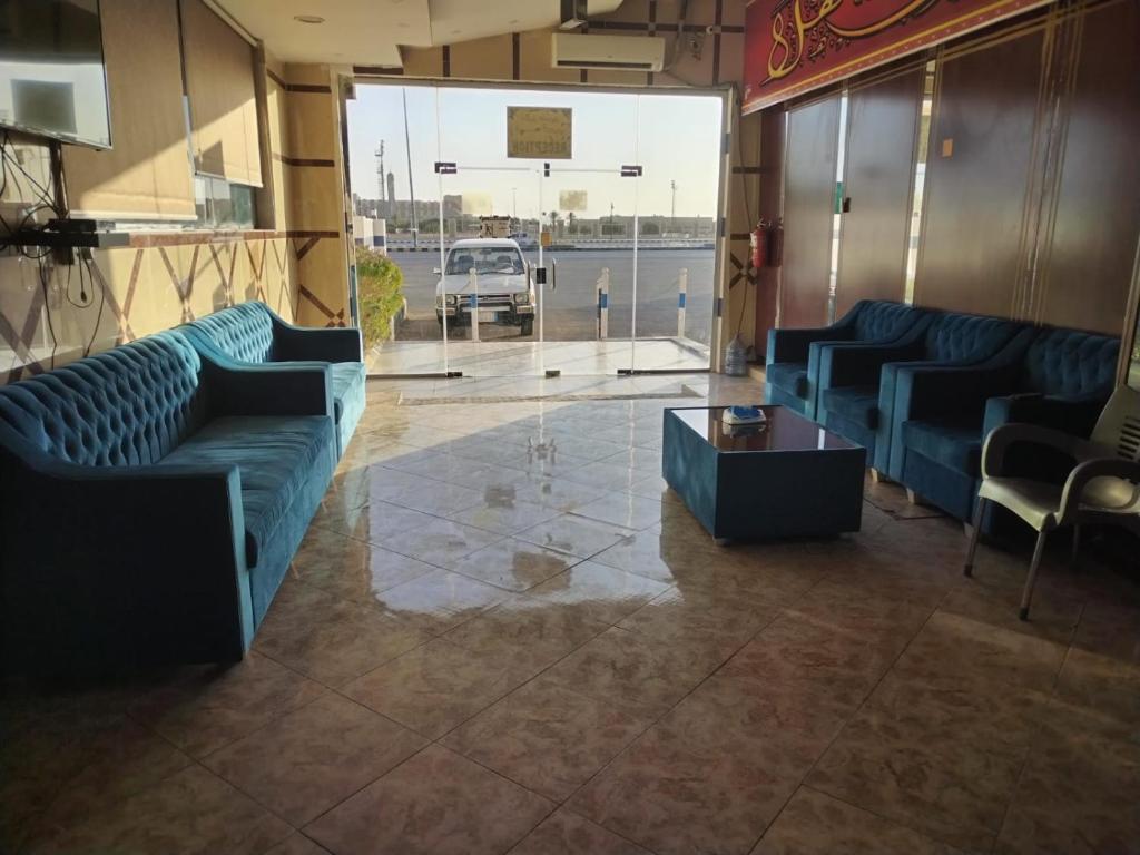 a living room with blue couches and a table at ناصر علي أبودهش للشقق المخدومة in Wadi Al Dawasir
