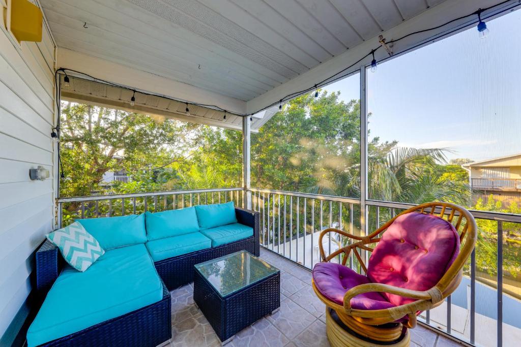 un porche cubierto con sofá y silla en Anglers Oasis with Boat Dock in Big Pine Key!, en Big Pine Key