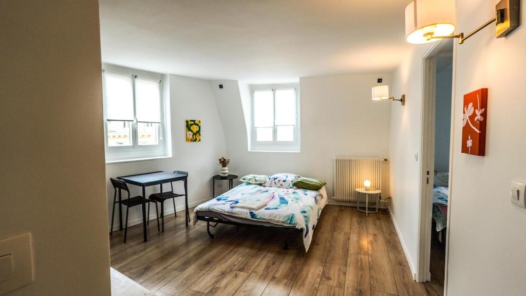 une chambre avec un lit et une table dedans dans l'établissement 09 Grand Sunny flat notre dame, à Paris