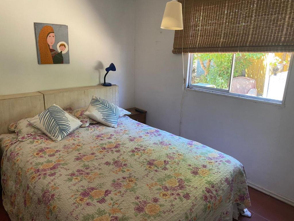a bedroom with a bed with pillows and a window at casa Marcela papudo in Papudo