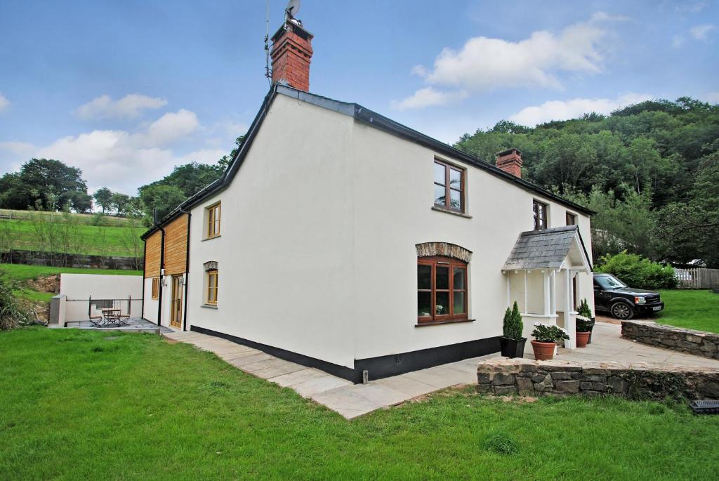 a large white house with a grassy yard at Exmoor Farmhouse in Bampton