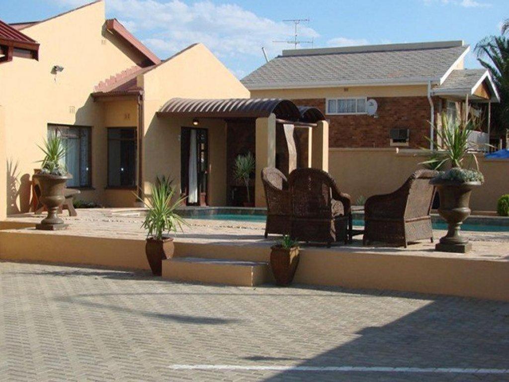a house with chairs in front of a swimming pool at La Casa Mia Guesthouse in Kimberley