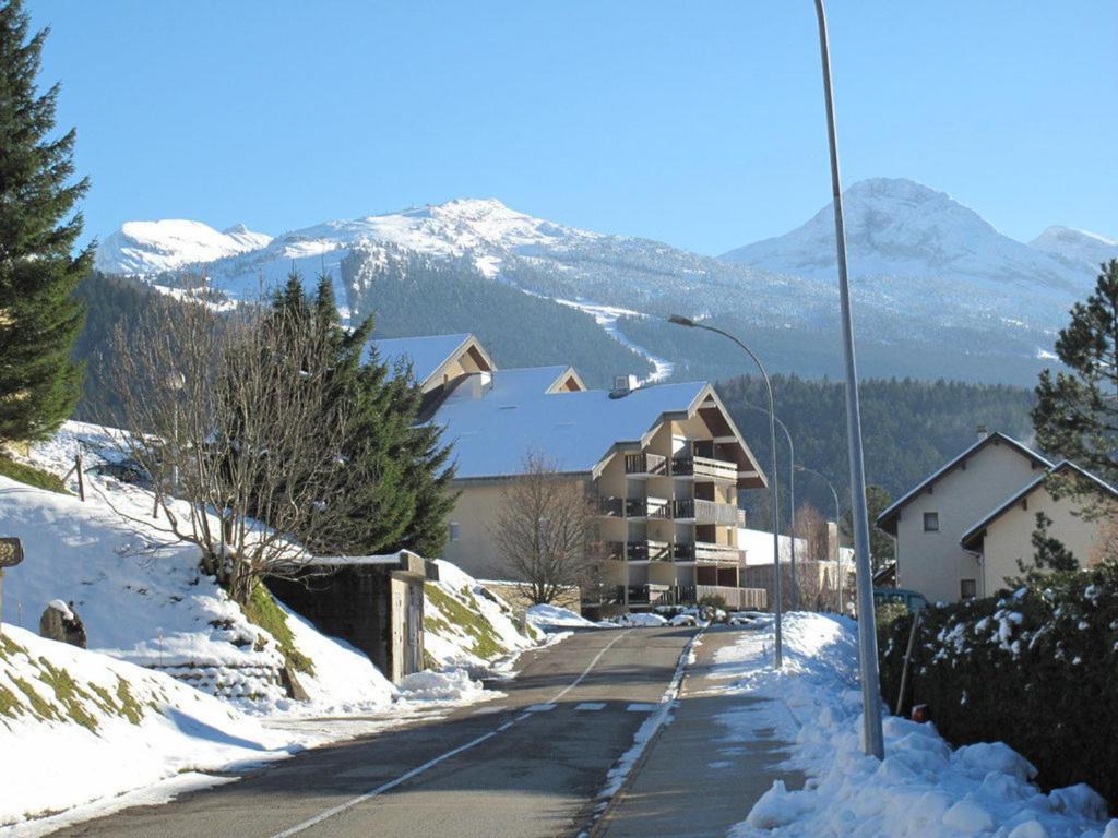 une rue enneigée avec un bâtiment et un éclairage de rue dans l'établissement Studio Cabine avec Balcon Proche Centre et Pistes, Parking et Navette Gratuite - FR-1-515-98, à Villard-de-Lans