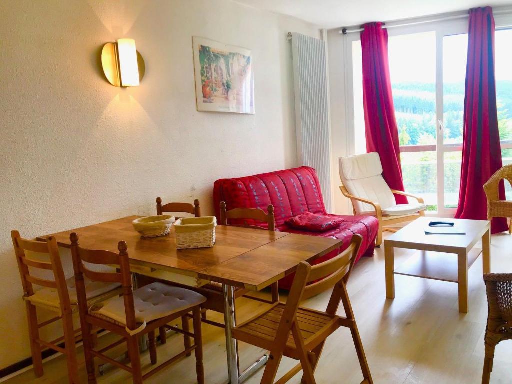 un salon avec une table et un canapé rouge dans l'établissement Appartement 43m² pied des pistes avec parking et WIFI - FR-1-515-40, à Villard-de-Lans