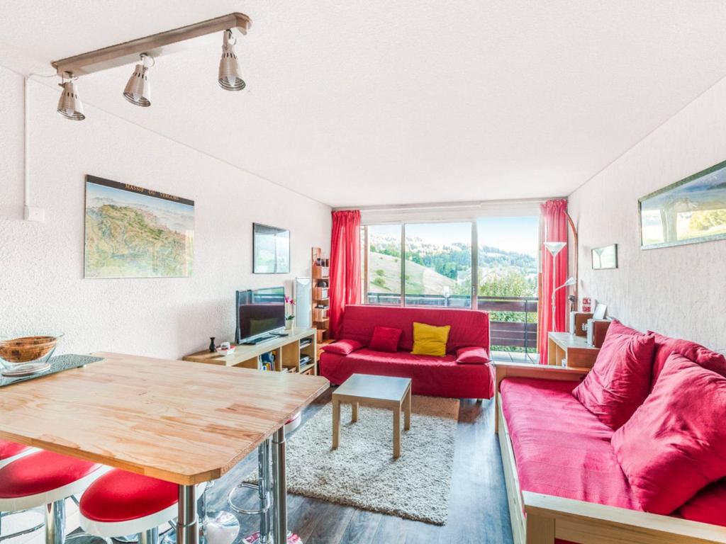 un salon avec un canapé rouge et une table dans l'établissement Studio cabine rénové avec parking couvert et casier à ski, proche centre - FR-1-515-96, à Villard-de-Lans