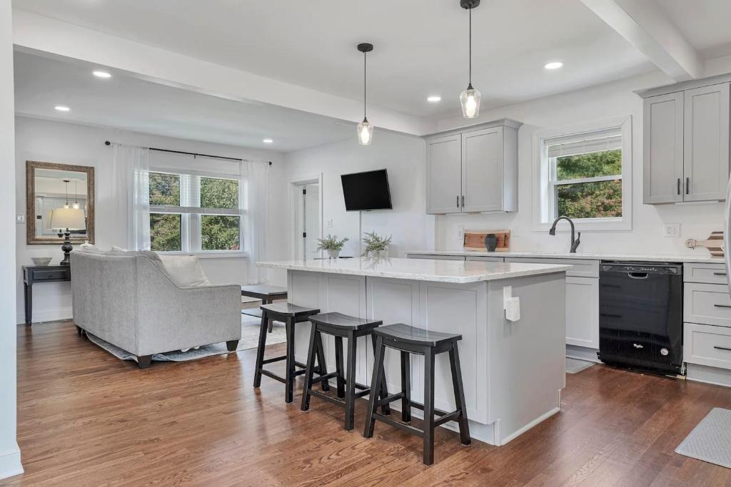 a kitchen with white cabinets and bar stools at Carytown Retreat Pet Friendly & Gourmet Kitchen in Richmond