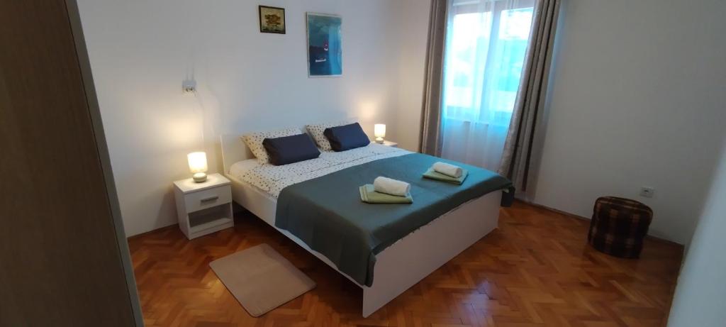 a bedroom with a bed with two towels on it at Apartment Lovor in Krk
