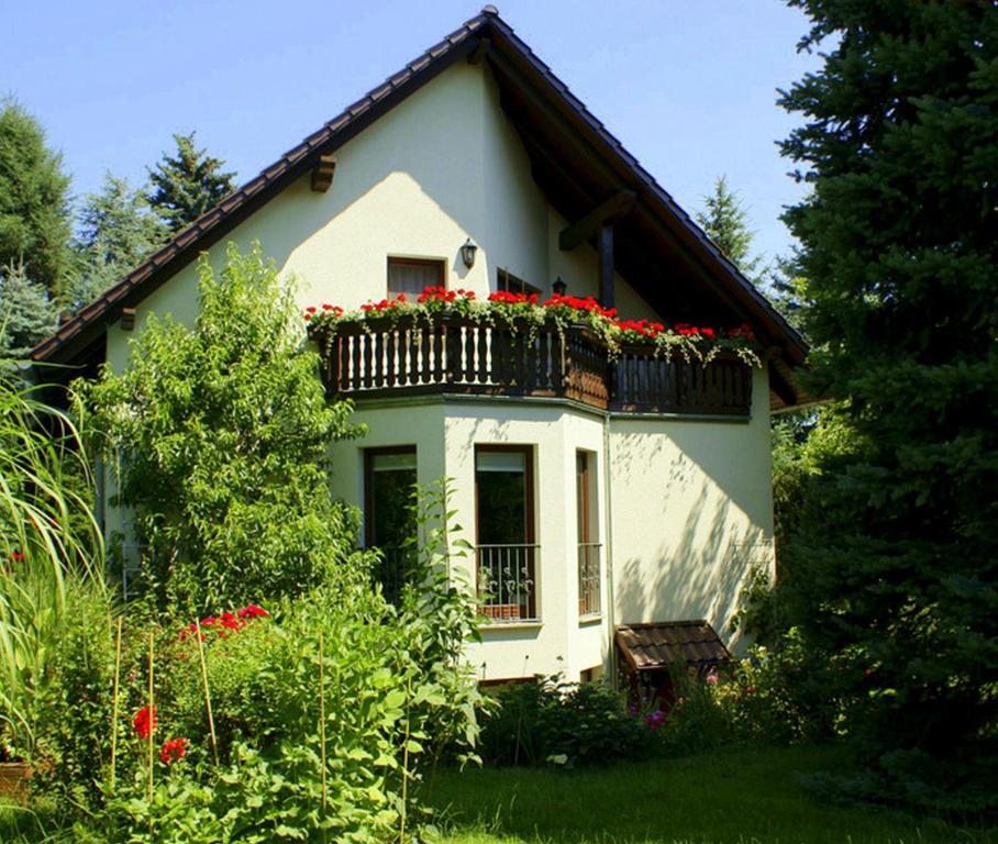 ein Haus mit einem Balkon mit roten Blumen darauf in der Unterkunft Ferienwohnung Ginkgo in Dresden