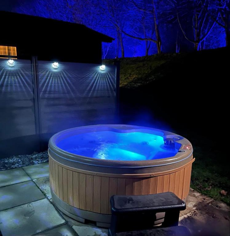 a hot tub in a backyard at night at Aspen Lodge in Morpeth