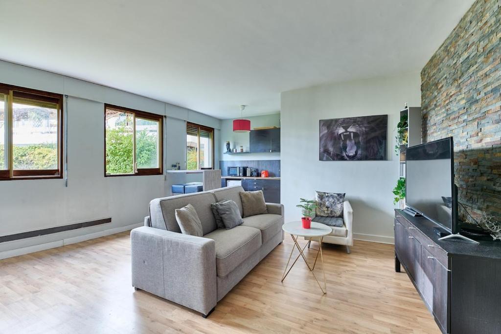 un salon avec un canapé et une télévision à écran plat dans l'établissement Parc des Expositions et Tour Eiffel, à Paris