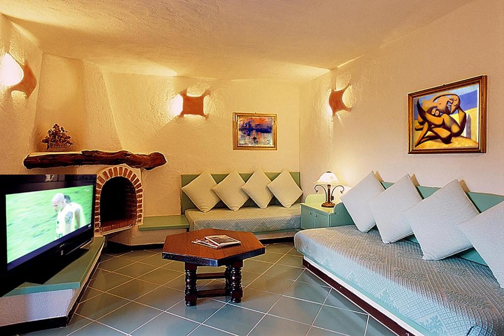 a living room with a couch and a flat screen tv at Hotel Don Diego in Porto San Paolo