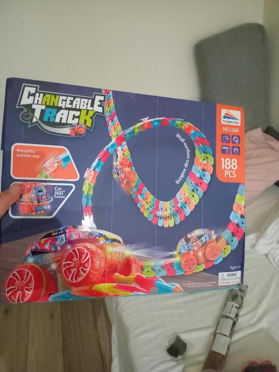 une boîte avec un jouet de voiture de course sur un lit dans l'établissement Chambre et salon proche centre ville et monuments, à Paris