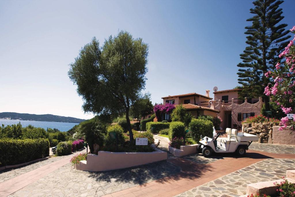 a villa with a scooter parked in a driveway at Hotel Don Diego in Porto San Paolo