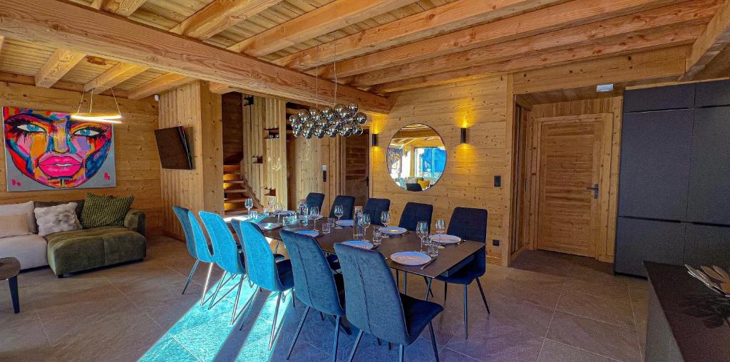 une salle à manger avec une grande table et des chaises bleues dans l'établissement Chalet Loune, à Les Deux Alpes