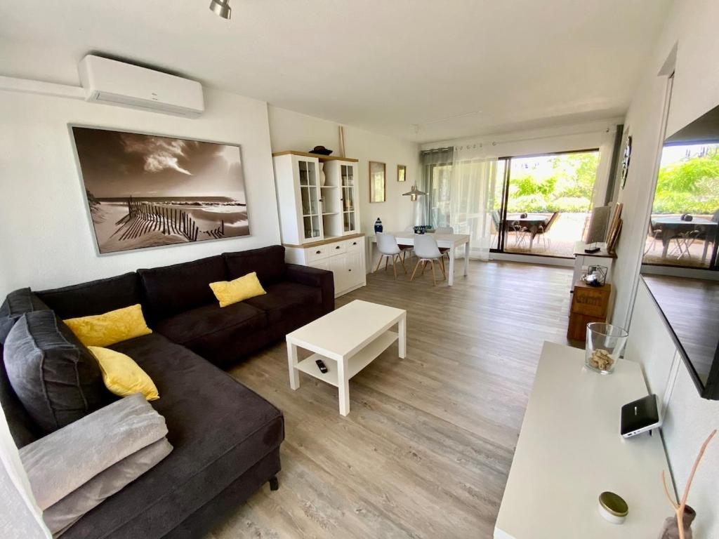 un salon avec un canapé et une table dans l'établissement T3 terrasse et piscine, au Barcarès