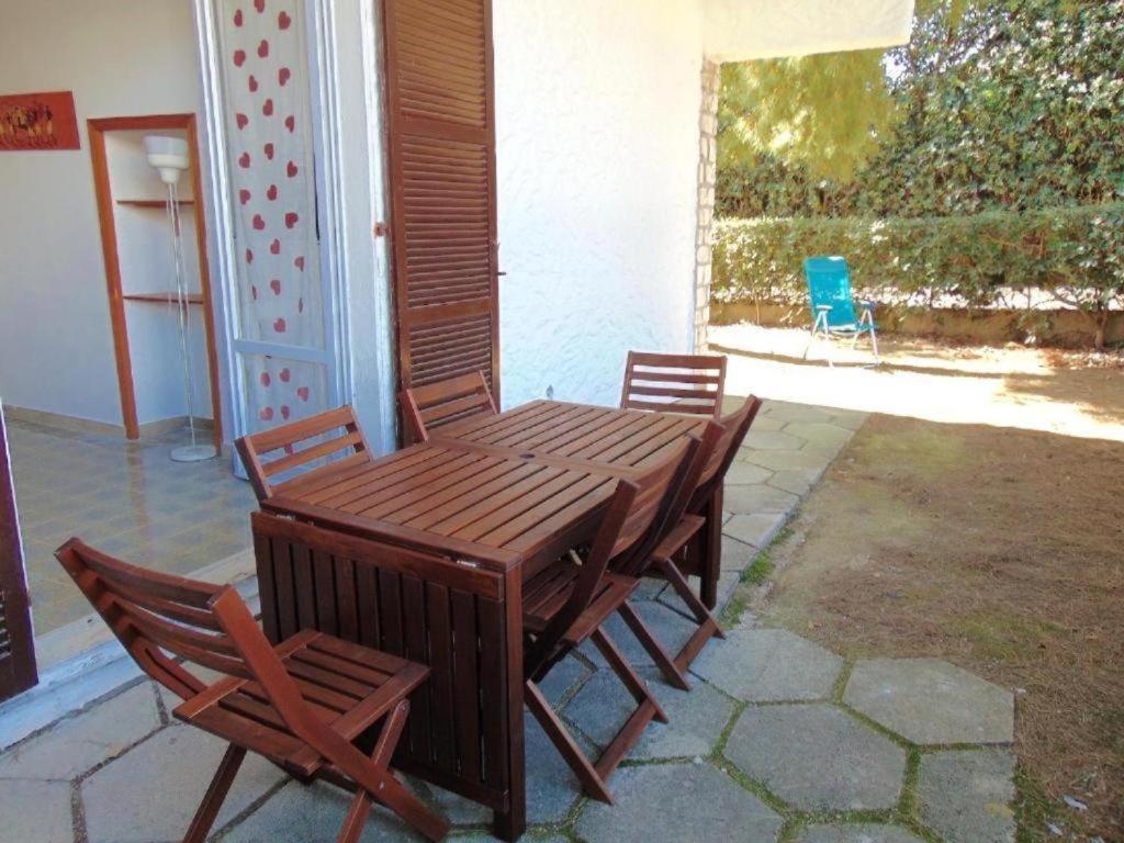 a wooden table and chairs on a patio at M080 - Marcelli, residence Mare Verde trilo con giardino in Marcelli