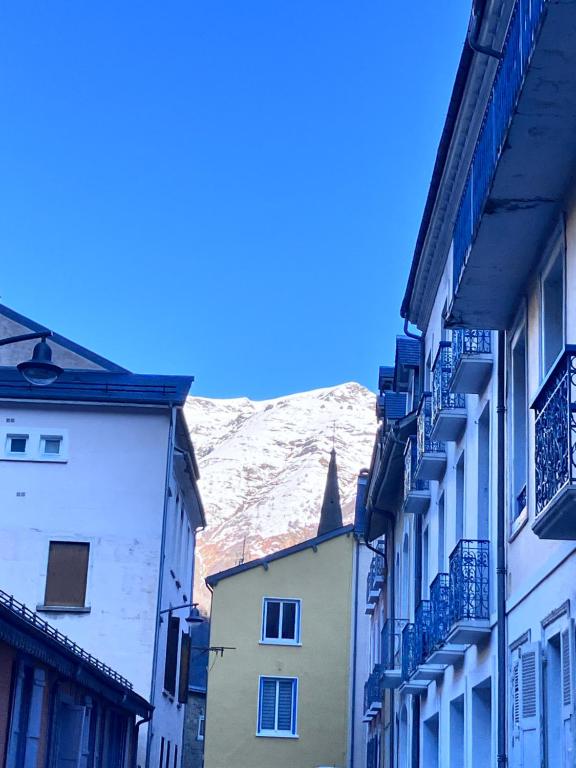 Une allée avec des bâtiments et une montagne en arrière-plan dans l'établissement Balaitous, à Cauterets